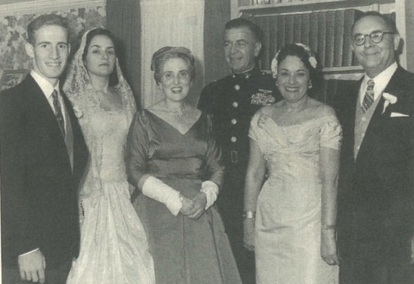 A bride and groom at a wedding with their parents