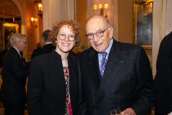 Woman with red hair in jacket with man in suit and tie