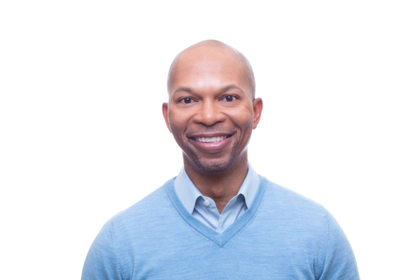 Man in blue V-neck sweater and open collar shirt