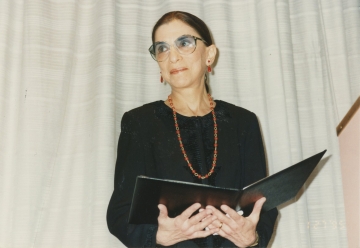 Justice Ruth Bader Ginsburg holding a folder and accepting the Medal for Excellence