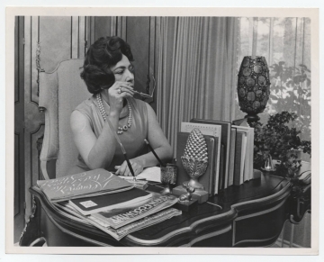 Judge Elreta Alexander in sleeveless dress sitting at an elegant desk