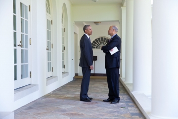 Two men in suits conferring on a walkway