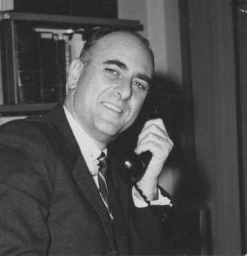 Black and white photo of Jack Weinstein ’48 holding a phone