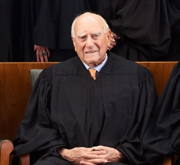 Older man in tie and black judge's robe