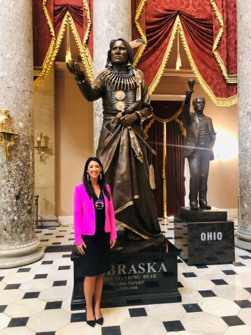 Woman in pink jacket in front of sculpture of Native American in U.S. Capitol