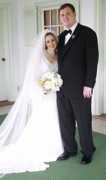 Bride in white dress holding bouquet with groom in tuxedo