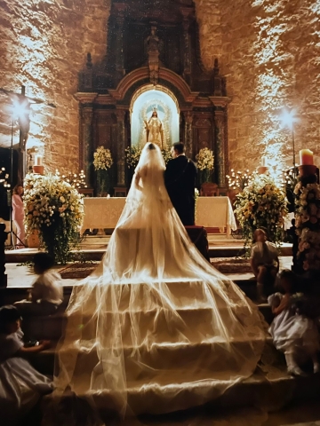 Bride with long train flowing over steps in church