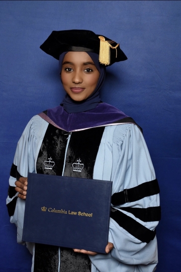 Kifaya Ibrahim in graduation robes, holding a diploma