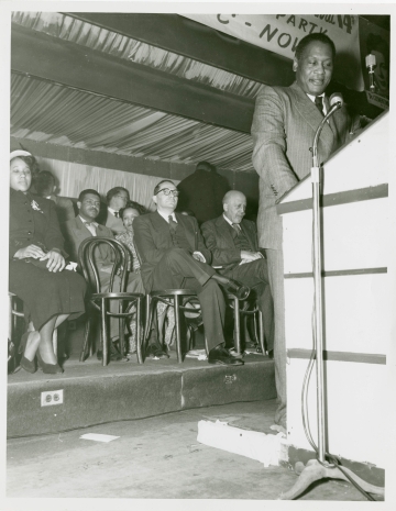 Paul Robeson, at podium, delivering a speech at a rally for W.E.B. Du Bois
