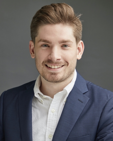 Man in white button down shirt and blue jacket