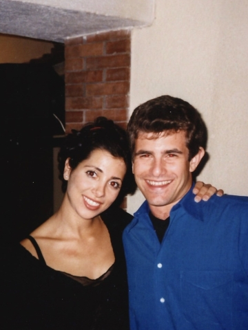 Woman in black top with arm around man in blue shirt