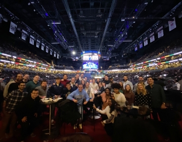 A group of students smile in a suite at Barclays Center