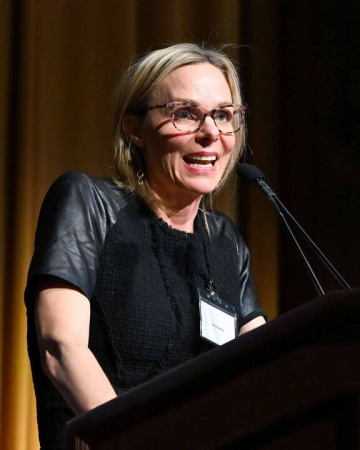Professor Anu Bradford speaking before a microphone